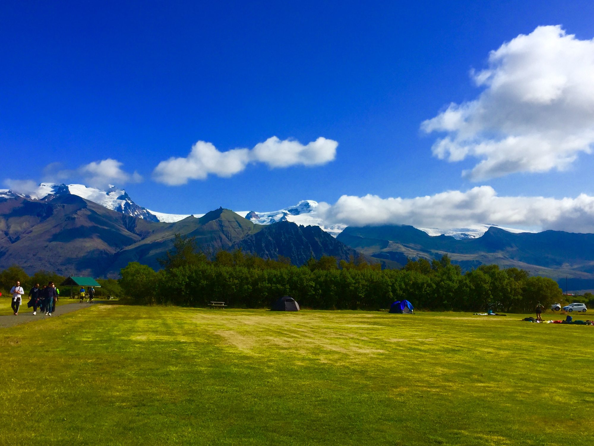 Tents pitched at a campsite with mountains behind